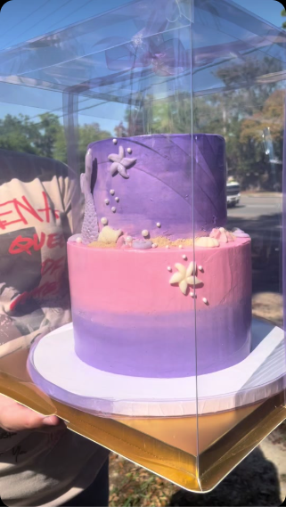 Purple and pink ombre mermaid-themed two-tier cake with edible starfish and pearls