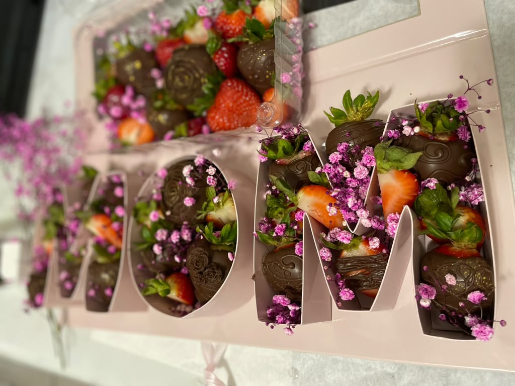 Chocolate covered strawberries arranged to spell MOM for Mother's Day